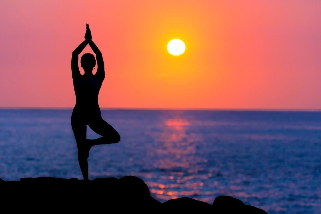 a person practicing yoga on the beach